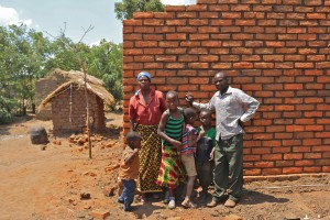 Stolt småbrukare som kunnat bygga sig ett tegelhus för pengarna som Plan Vivo-träden givit.